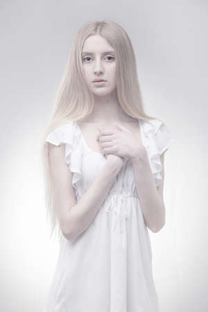 fairy blond girl in glowing light on grey gradient backgroundの写真素材