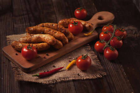 Grilled sausage with fresh herbs on wodden tableの写真素材