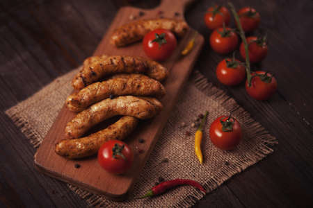 Grilled sausage with fresh herbs on wodden tableの写真素材