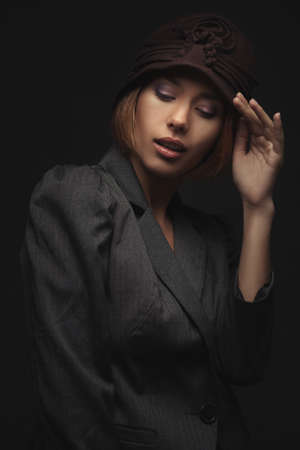 Elegant blond retro woman in hat over dark backgroundの写真素材