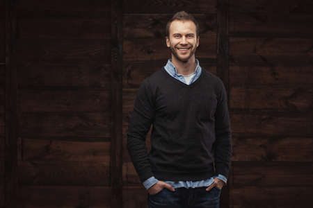 Portrait of a young handsome man fashion model over wooden backgroundの写真素材