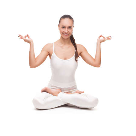 young beautiful woman yoga posing on isolated white studio backgroundの写真素材