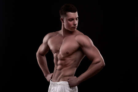 young athlete bodybuilder man isolated over black backgroundの写真素材