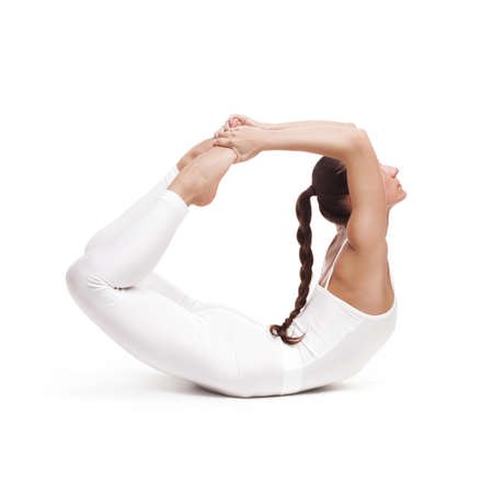 young beautiful woman yoga posing on isolated white studio backgroundの写真素材