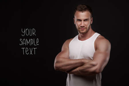 Young handsome  man with  muscular chest with copyspase on dark backgroundの写真素材
