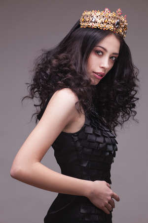 Fashion shot of a woman with diadem in black dress and red lipstickの写真素材