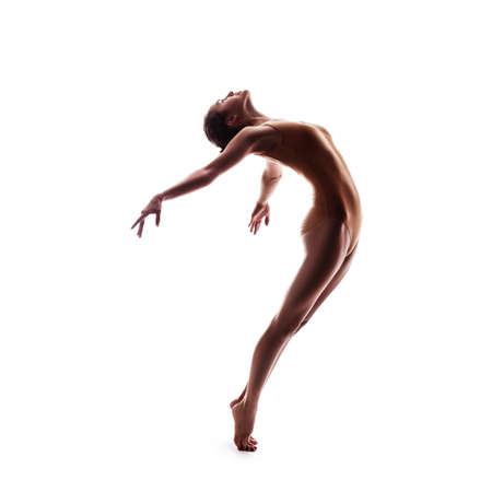 silhouette of young beautiful dancer in beige swimsuit isolated on white studio backgroundの写真素材