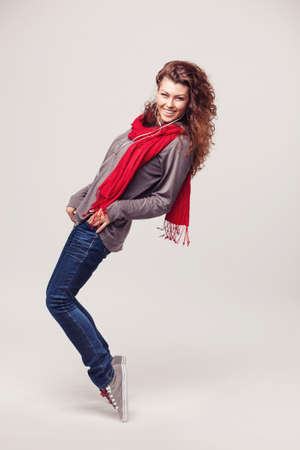 Dancing hipster girl with headphones on light backgroundの写真素材