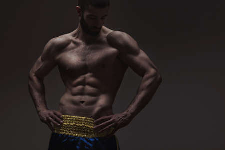 strong athletic man on dark grey gradient backgroundの写真素材