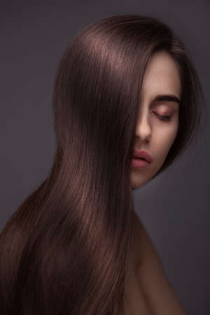 portrait of Beautiful Woman with Long Hair isolated over dark backgroundの写真素材