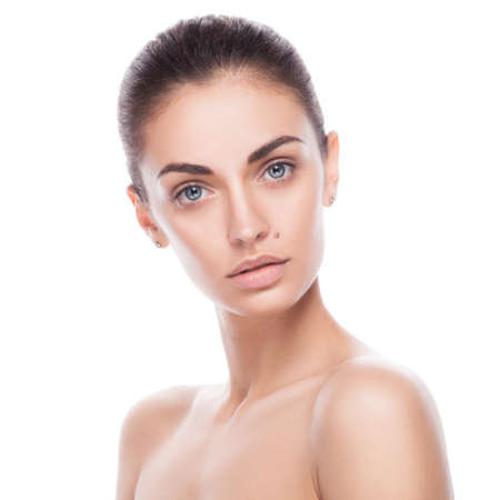 closeup portrait of young adult woman with clean fresh skin isolated on whiteの写真素材