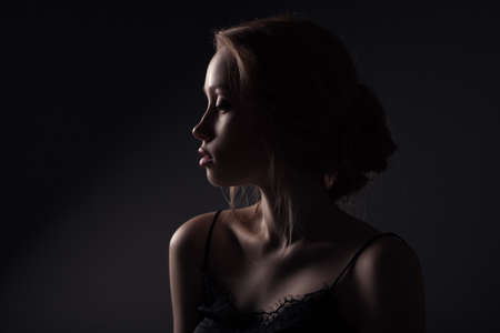 Closeup lowkey portrait of redhead woman on dark backgroundの写真素材