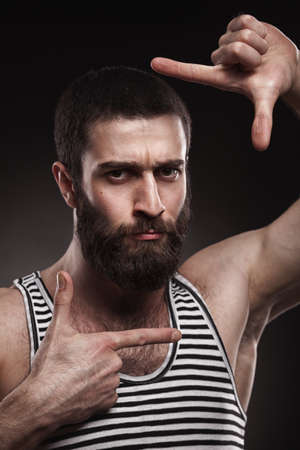 studio portrait of beardy man in singlet on grey gradient backgroundの写真素材