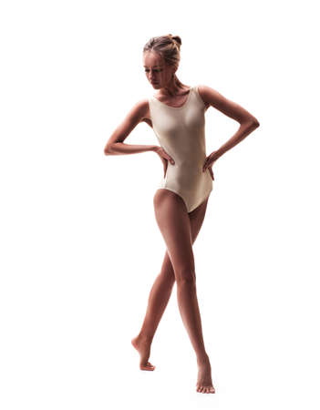 young beautiful dancer in beige swimsuit posing on a isolated white studio backgroundの写真素材