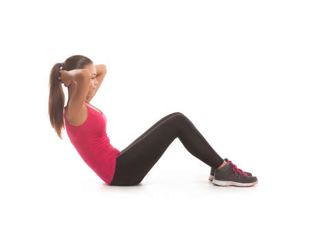 Fitness woman in pink shirt and black pants doing stretching exercise - isolated over whiteの写真素材