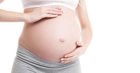 Close-up of pregnant woman touching her bellyの写真素材