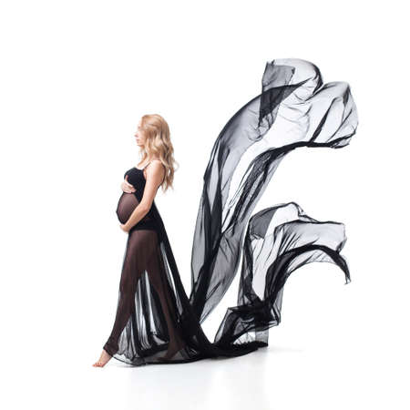 pregnant young woman in flying black dressの写真素材