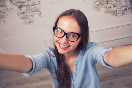 Beautiful young woman making self-portrait onの写真素材