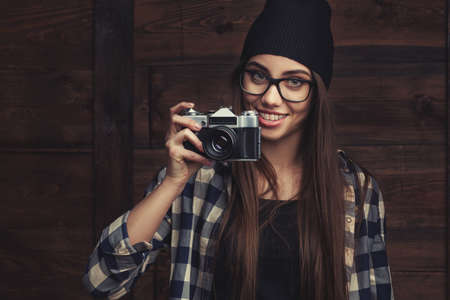 smiling girl in glasses with vintage cameraの写真素材