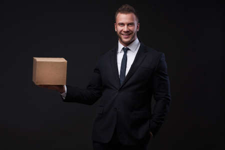 Portrait of young businessman holding a boxの写真素材