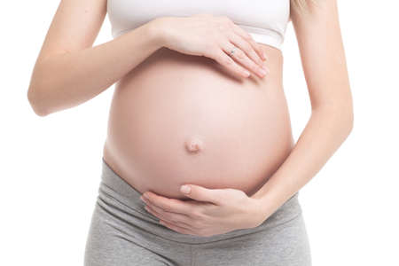 Close-up of pregnant woman touching her bellyの写真素材