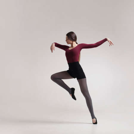 young woman dancer in maroon swimsuit posingの写真素材