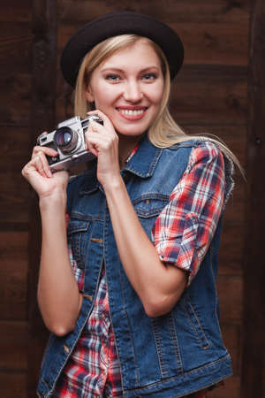 young smiling girl in black hat with vintage cameraの写真素材