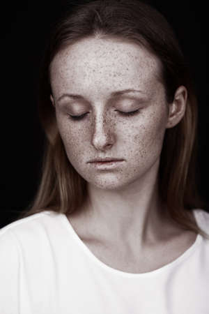closeup studio portrait of freckled woman without makeupの写真素材
