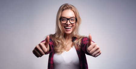 Beautiful hipster woman portrait showing thumbs upの写真素材