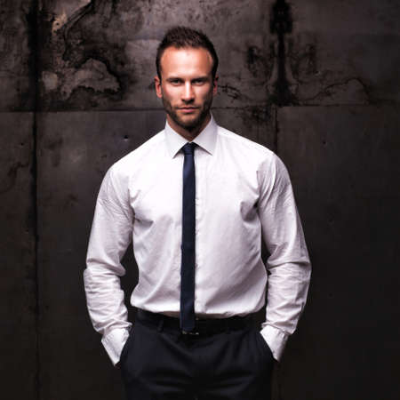 handsome man wearing white shirt on a grunge background.の写真素材