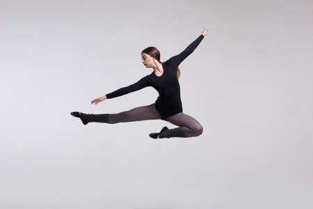 young woman dancer in black swimsuit posing