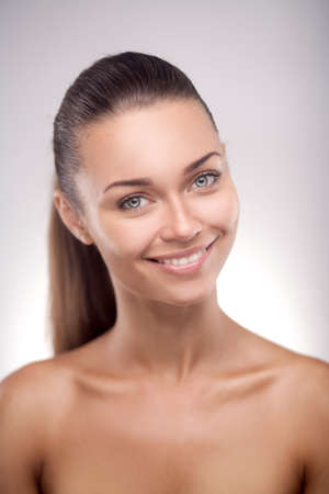 brunette woman with glad smile showing her perfect teeth posingの写真素材
