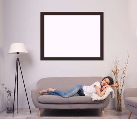 beautiful happy young woman lying on a sofaの写真素材