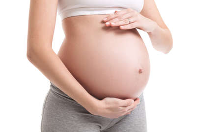 Close-up of pregnant woman touching her bellyの写真素材