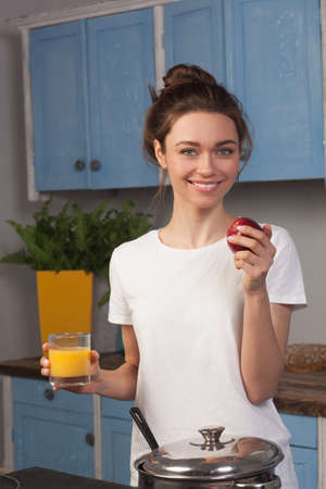 Happy young woman on the kitchenの写真素材