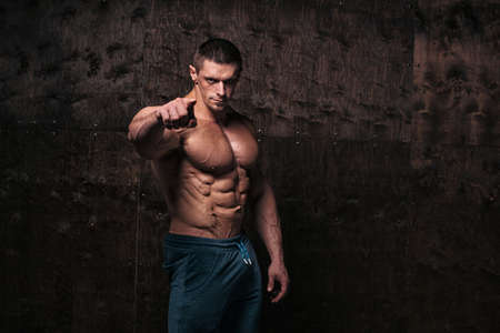 Sporty and healthy muscular man on dark grunge backgroundの写真素材
