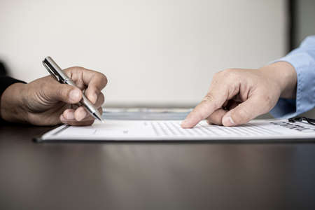 Business women are signing a joint corruption agreement with business partners and accepting bribes in the upcoming big project, corruption is illegal and immoral. The concept of corruption.の写真素材