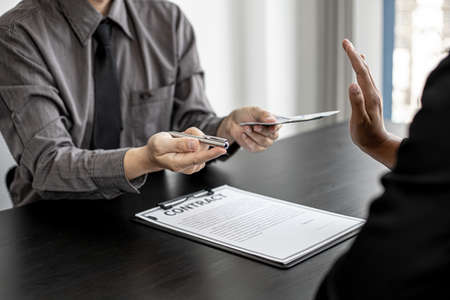 The businesswoman raised her hand to deny this conscience, she did not sign and accept money for participating in the upcoming large-scale corruption scheme, bribing was illegal and immoral.の写真素材