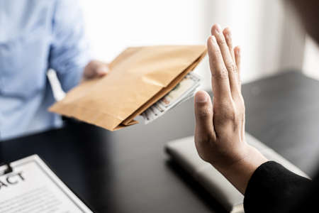 The businesswoman raised her hand to deny this conspiracy and did not accept the money for bribery to jointly corrupt the upcoming grand scheme, bribery is illegal and immoral. Corruption concept.の写真素材