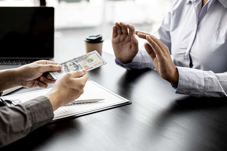 The businesswoman raised her hand to deny this conscience, she did not sign and accept money for participating in the upcoming large-scale corruption scheme, bribing was illegal and immoral.の写真素材