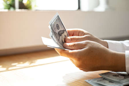 A man is picking up a dollar bill inside, he's going to take the money out of his wallet to pay for the food. Personal finance concept.の写真素材