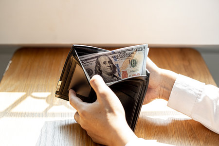 A man is opening a wallet with a dollar bill inside, he is about to take the money out of the wallet to pay for the food. Personal finance concept.の写真素材
