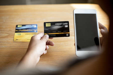 People are holding credit cards and smartphones to pay for products ordered through the website....