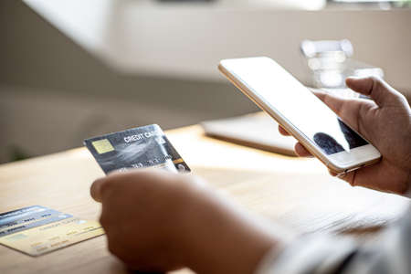 People are holding credit cards and smartphones to pay for products ordered through the website. Credit cards can pay for products online. Online shopping ideas.の写真素材