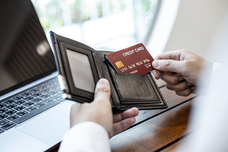 Men are pulling their credit cards out of their wallets. He is about to pay for food by credit card at restaurants, credit cards can be used for general stores and online shopping. Credit card conceptの写真素材