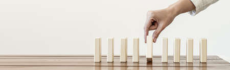 A close-up shot of a businessman holding the wooden blocks in a row, the wood blocks compare to the business risk management. The concept of risk management. copy space.の写真素材