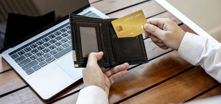 Men are pulling their credit cards out of their wallets. He is about to pay for food by credit card at restaurants, credit cards can be used for general stores and online shopping. Credit card conceptの写真素材