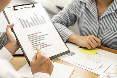 Two businessmen are working in a meeting room, they are documenting the company's finances and verifying the accuracy of the information to bring them to the shareholder's meeting. Financial concept.の写真素材