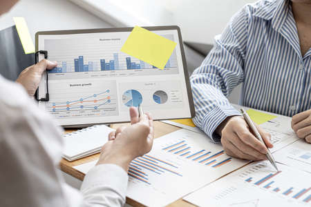 Finance workers are working together to prepare company financial documents for the meeting with management, together they are checking the accuracy of the information. Financial concept.の写真素材