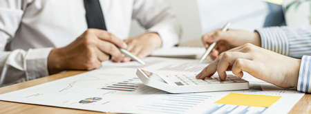 Two businessmen are meeting together on corporate finance to plan for the company to grow, referring to the financial documents provided by the Finance Department. Financial concept.の写真素材